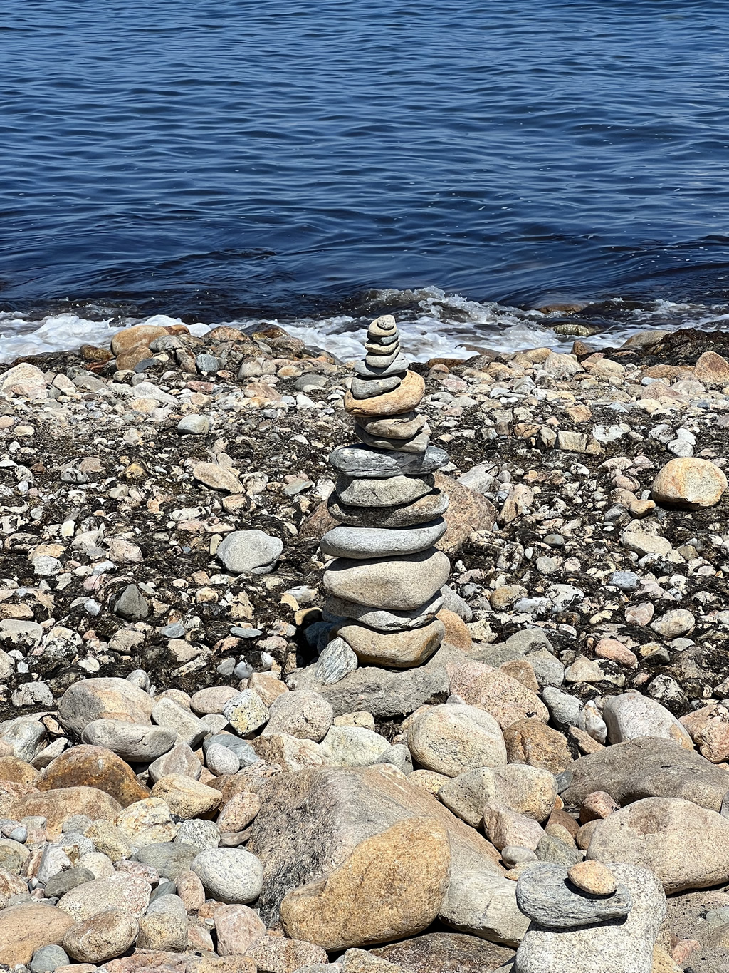stack of balanced rocks near the water edge of a lake